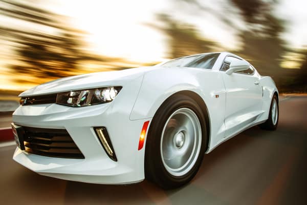 A white sportscar in motion showcasing speed and style on an open road