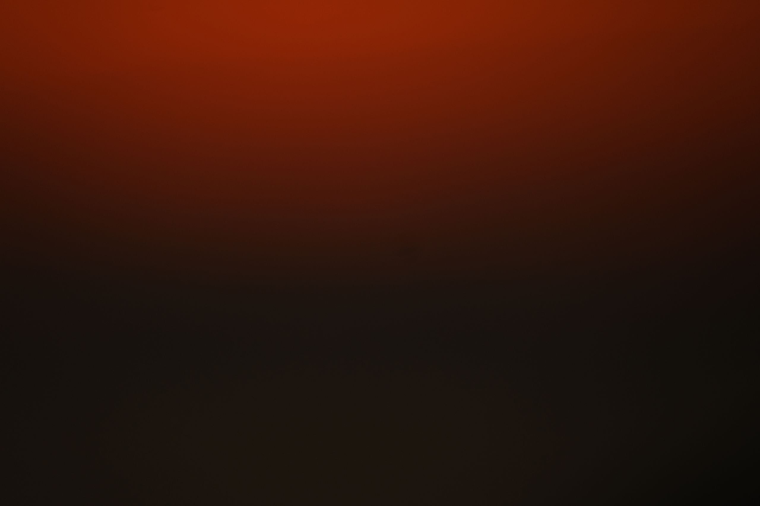 Abstract red and black gradient background with ample copy space.