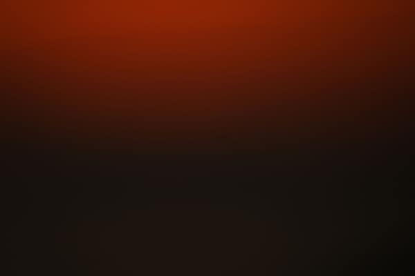 Abstract red and black gradient background with ample copy space.
