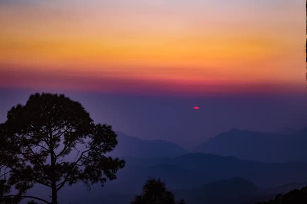 Beautiful sunset over the misty hills of Uttarakhand, India, with vibr