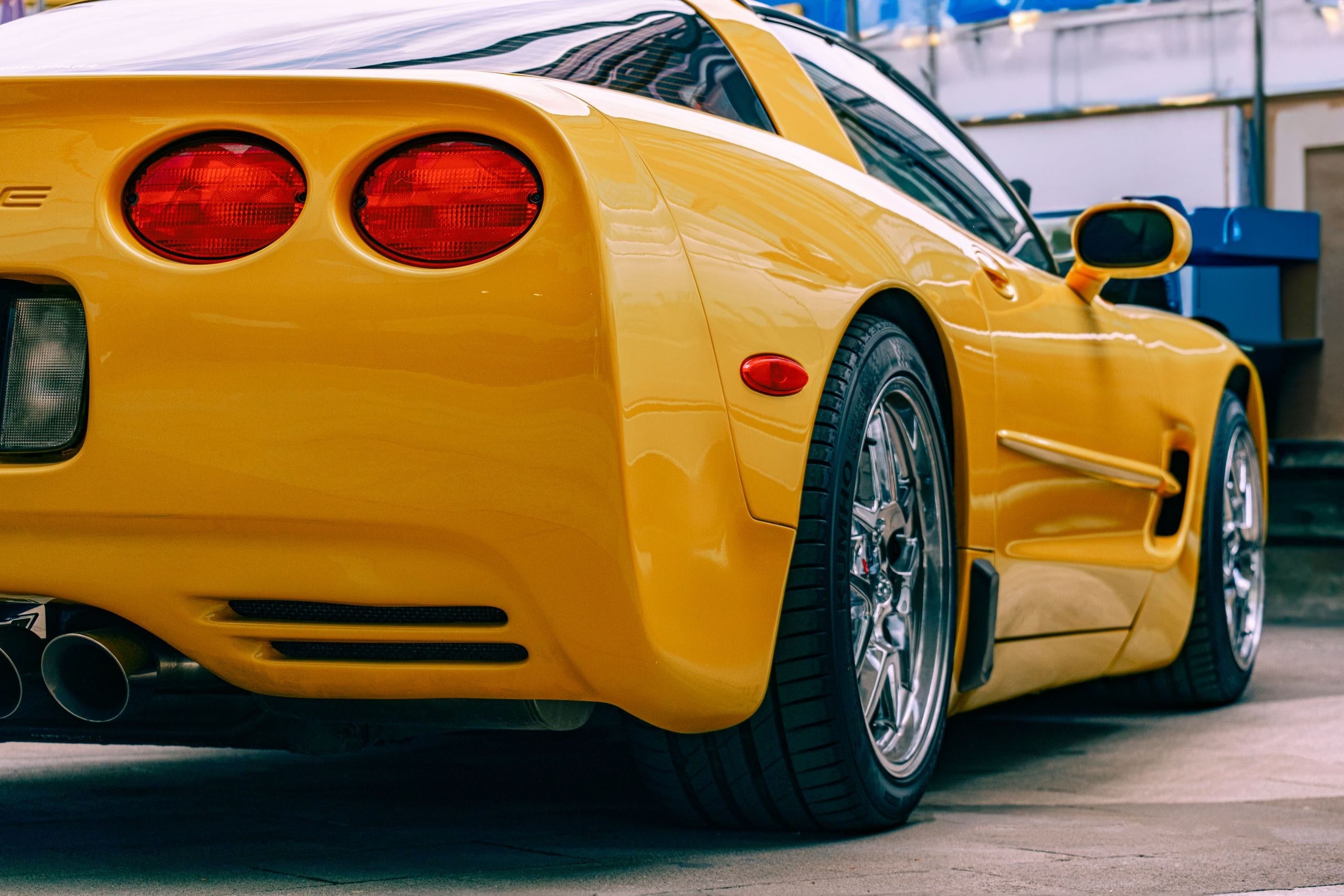 Close-up of a yellow Chevrolet Corvette parked outdoors, showcasing it