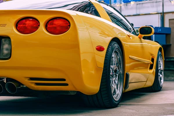 Close-up of a yellow Chevrolet Corvette parked outdoors, showcasing it