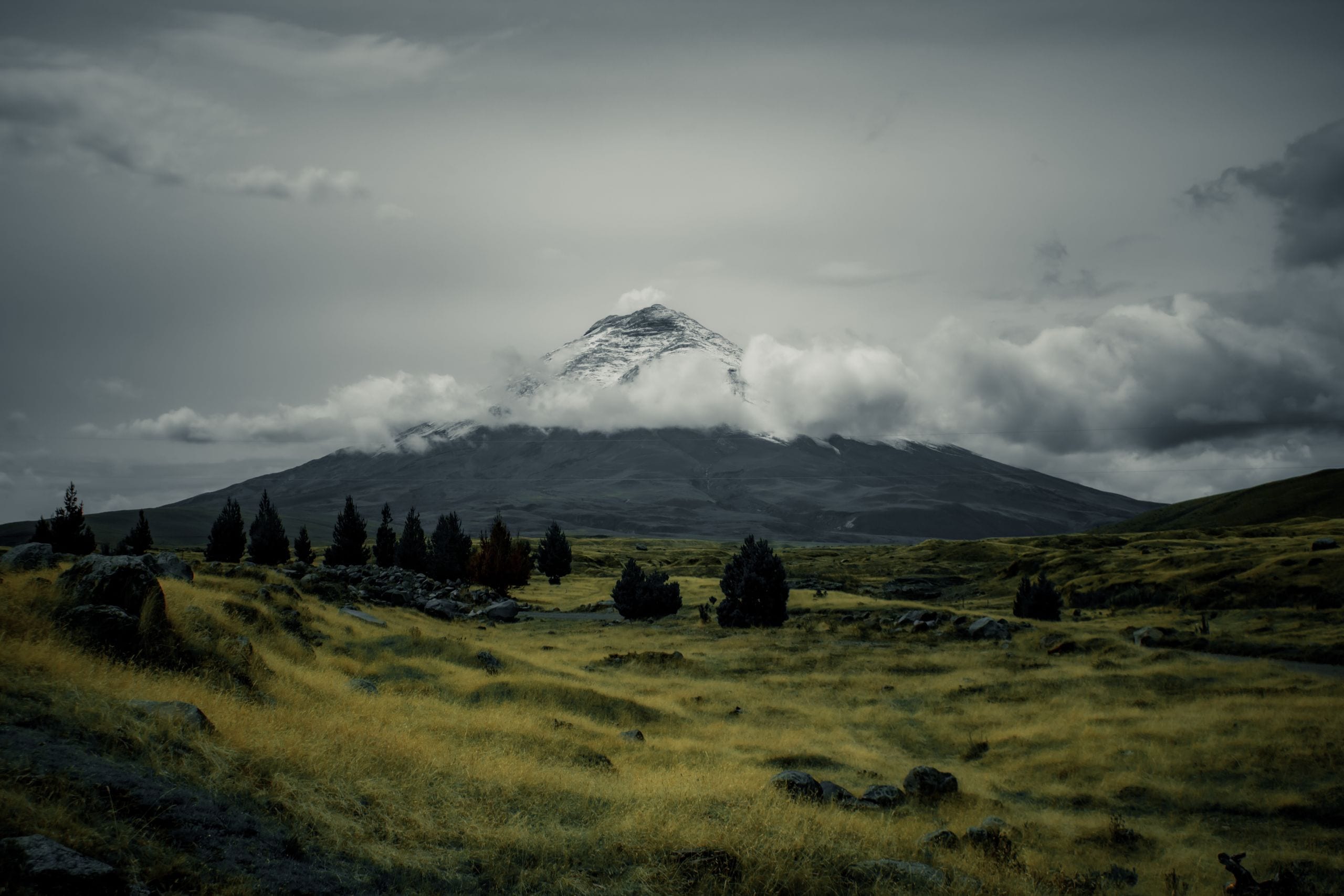 Scenic view of a snowcapped volcano amidst a cloudy sky and expansive