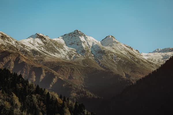 A picturesque view of snow-capped mountains under a clear blue sky.