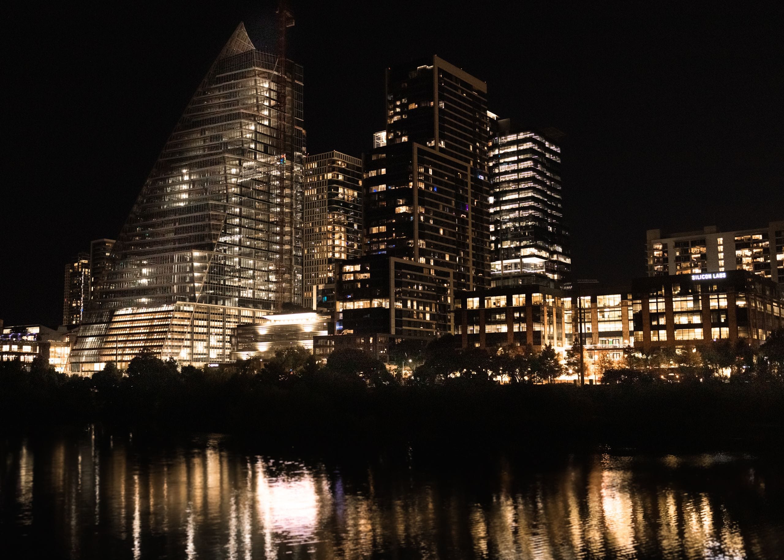 Illuminated skyscrapers reflecting in the river at night in downtown A