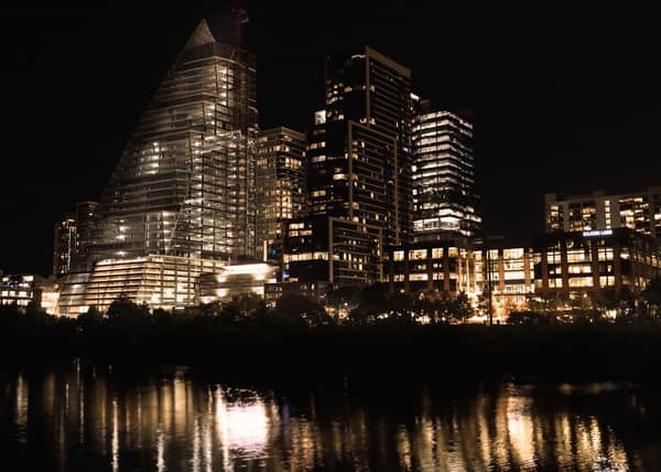 Illuminated skyscrapers reflecting in the river at night in downtown A
