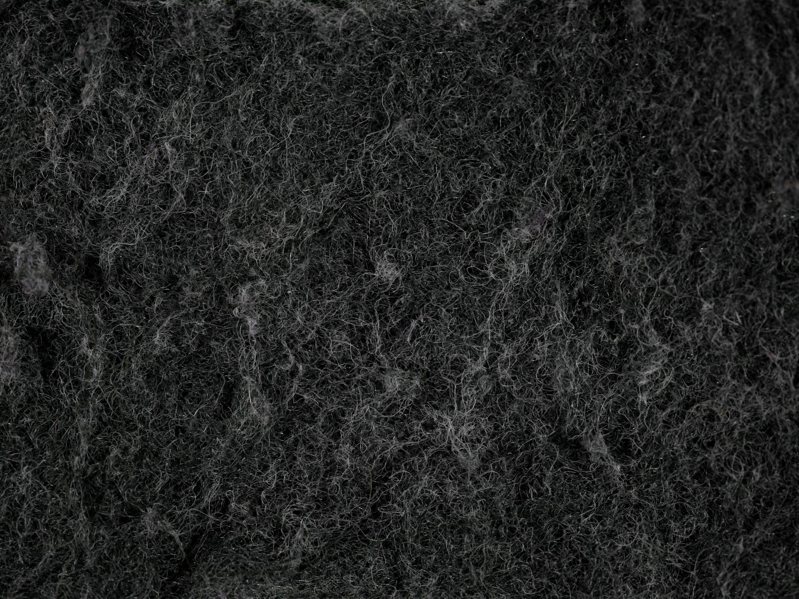 Detailed texture of a black dish sponge captured in macro photography,
