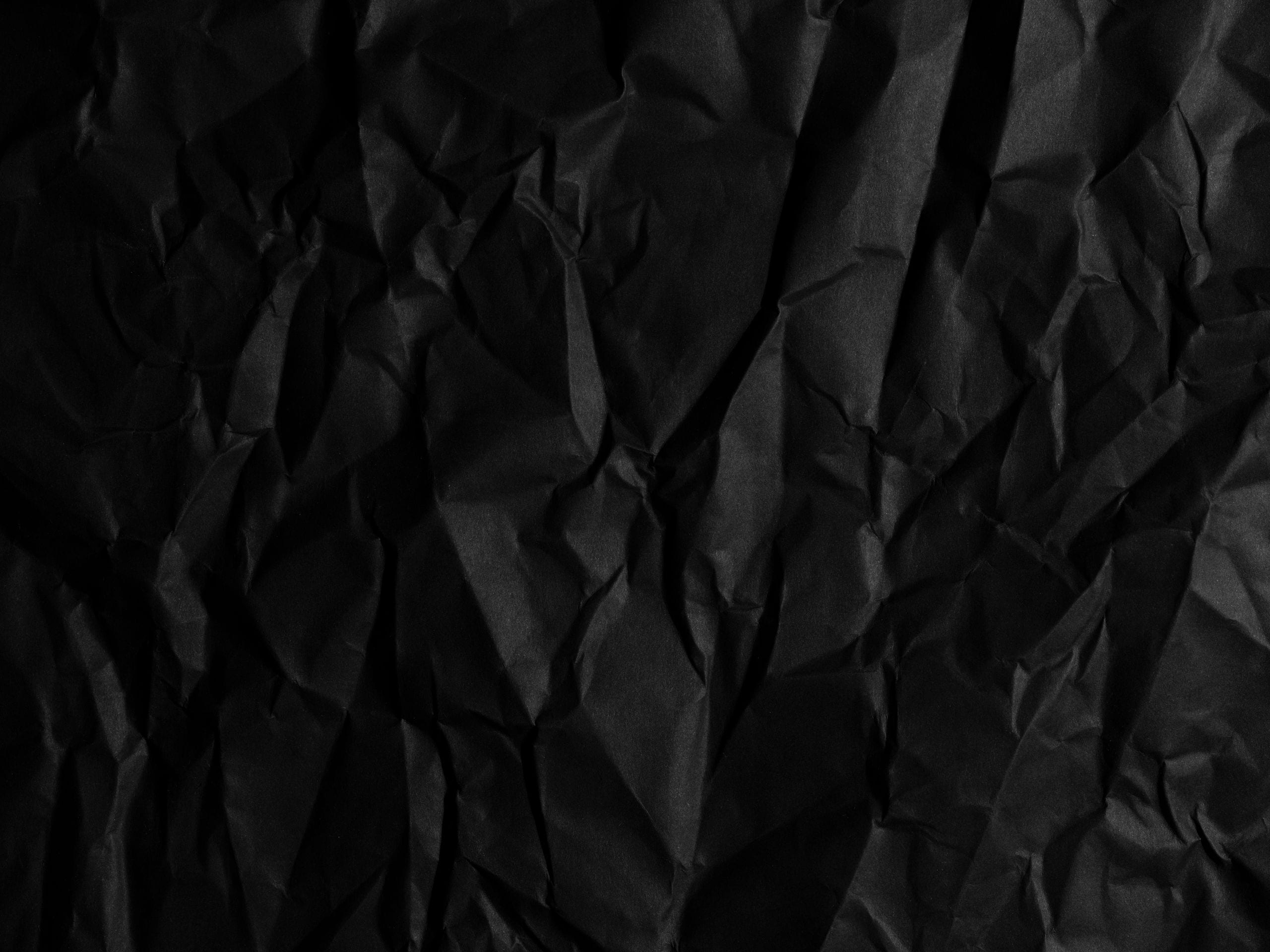 Close-up of a black crumpled paper texture, ideal for backgrounds or a