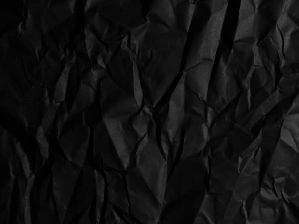 Close-up of a black crumpled paper texture, ideal for backgrounds or a