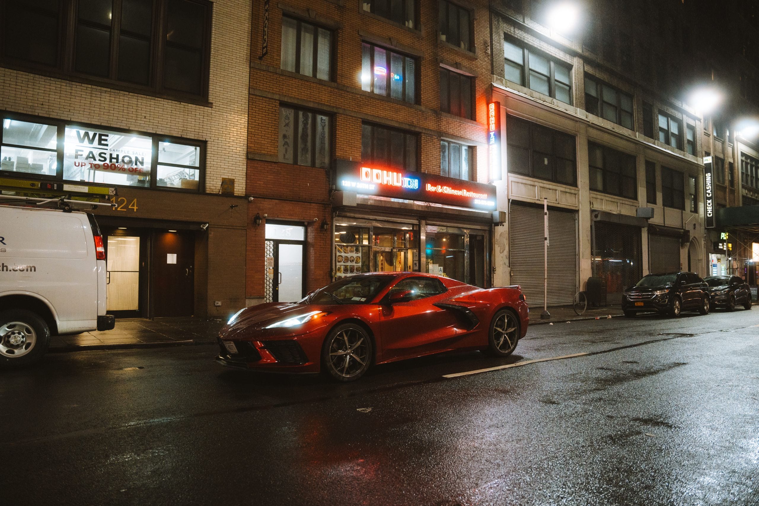 A sleek red sports car, possibly a Chevrolet Corvette, parked on a bus