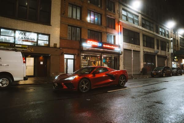 A sleek red sports car, possibly a Chevrolet Corvette, parked on a bus