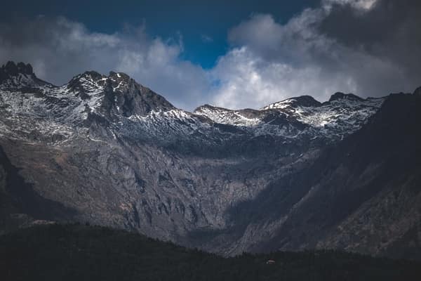 A breathtaking view of rugged, snow-capped mountains under a dramatic 