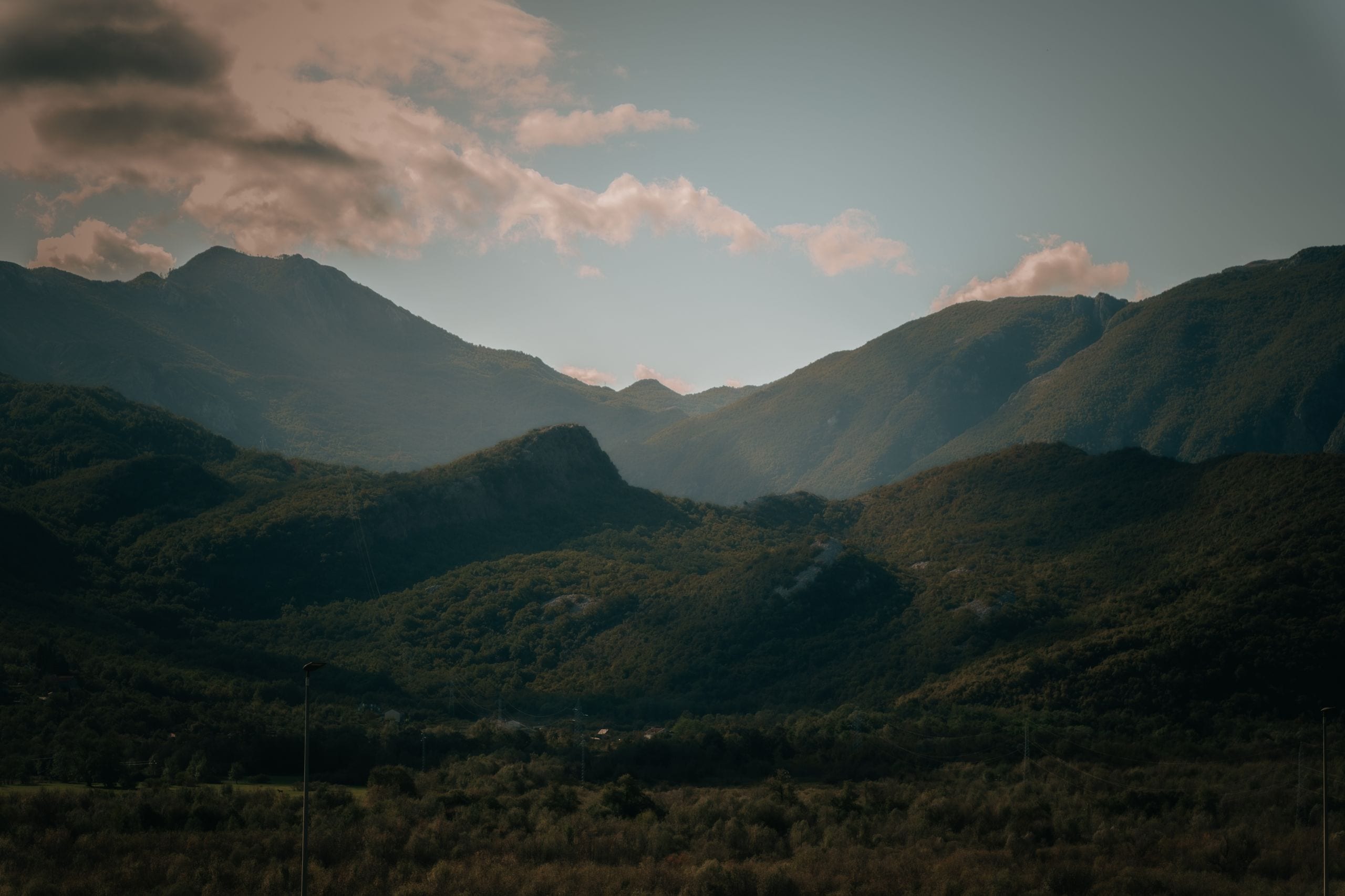 A peaceful view of mountains with lush greenery under a cloudy sky, ev