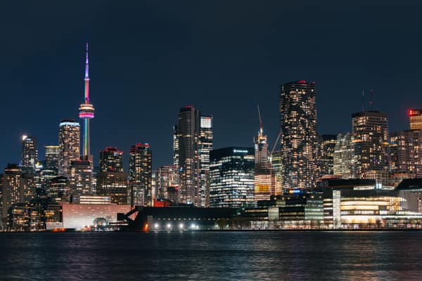 Vibrant night view of Toronto skyline featuring the illuminated CN Tow