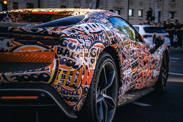 Dynamic image of a sports car with a vibrant graffiti-style wrap, capt