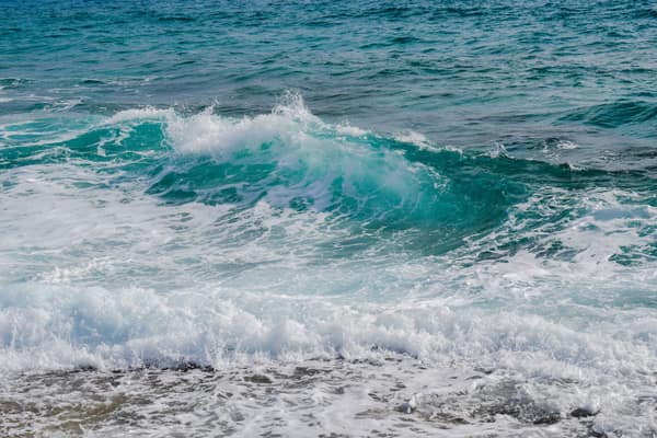 Vibrant ocean waves crashing onto the shore, showcasing the energy and
