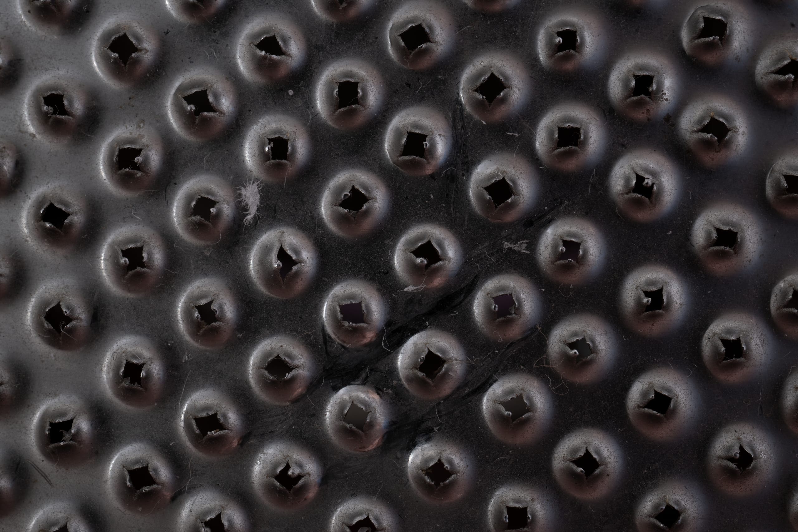 Macro shot of a black textured surface with raised circular patterns a
