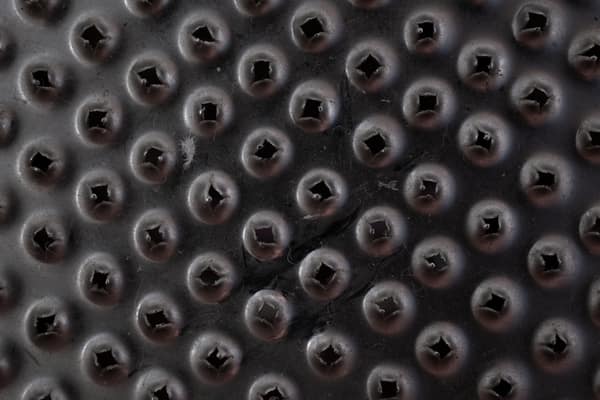 Macro shot of a black textured surface with raised circular patterns a