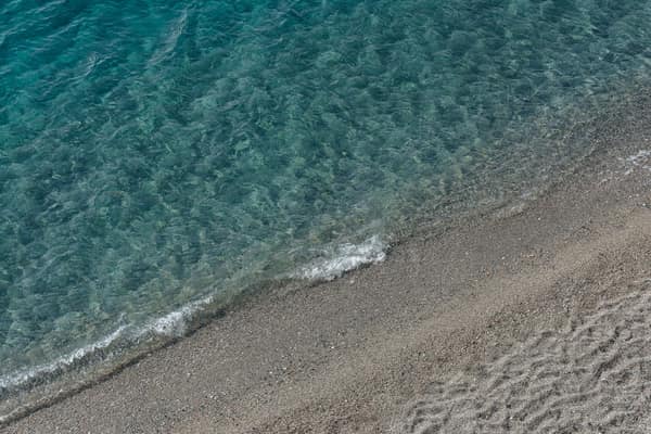 A serene beach scene with gentle waves meeting the sandy shore, perfec
