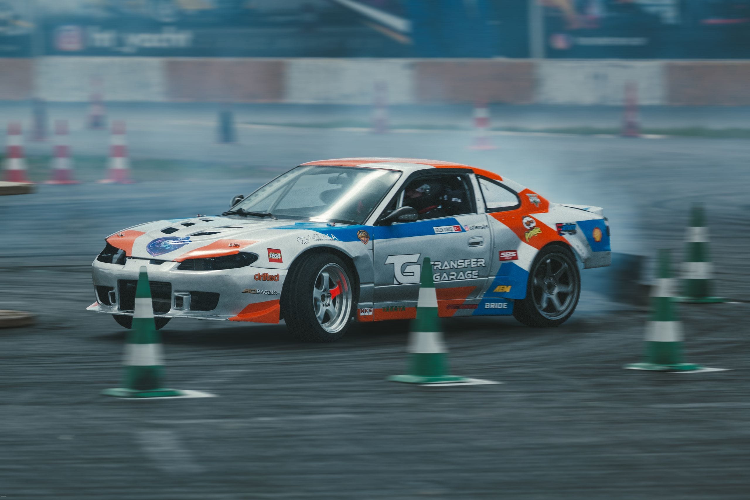 Action-packed scene of a customized car drifting around cones on a rac