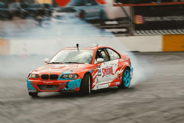 Dynamic drift racing car with colorful livery smoking tires at high sp