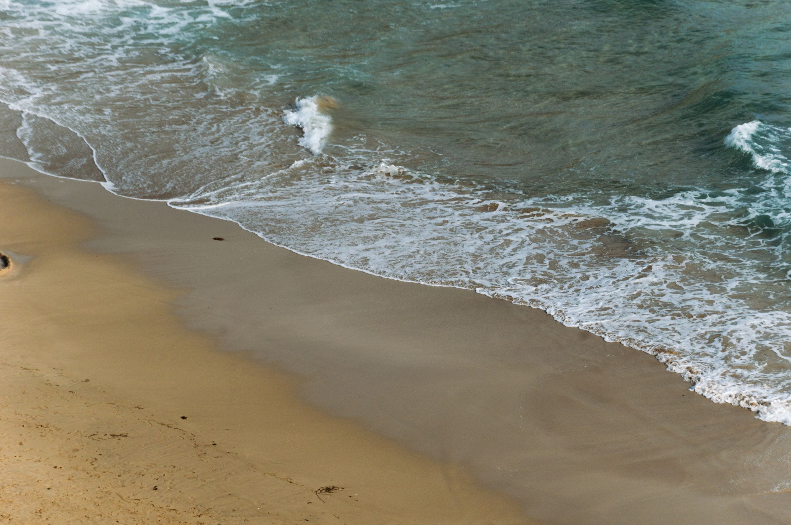 Serene beach view with gentle waves lapping against the shore, perfect