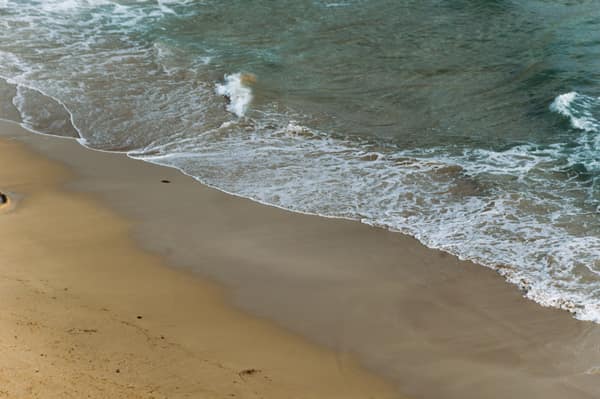Serene beach view with gentle waves lapping against the shore, perfect
