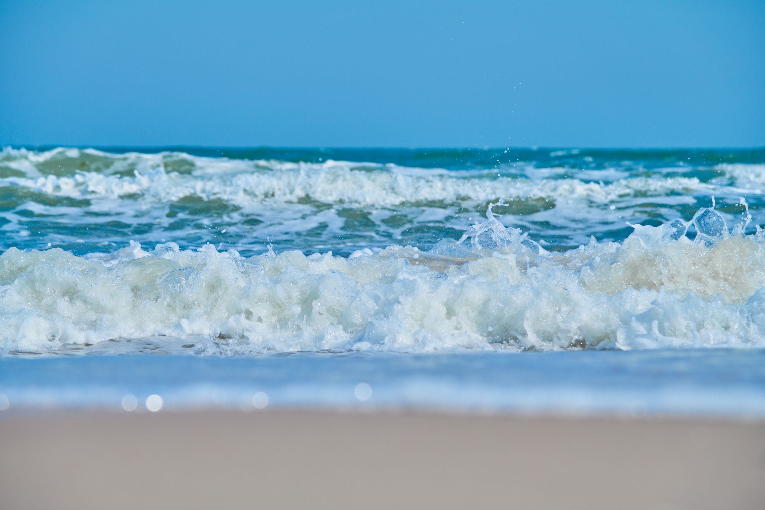 Tranquil scene of ocean waves gently crashing onto a sandy beach under