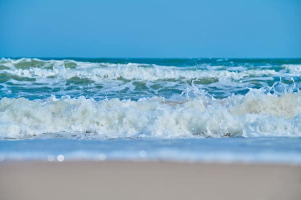 Tranquil scene of ocean waves gently crashing onto a sandy beach under
